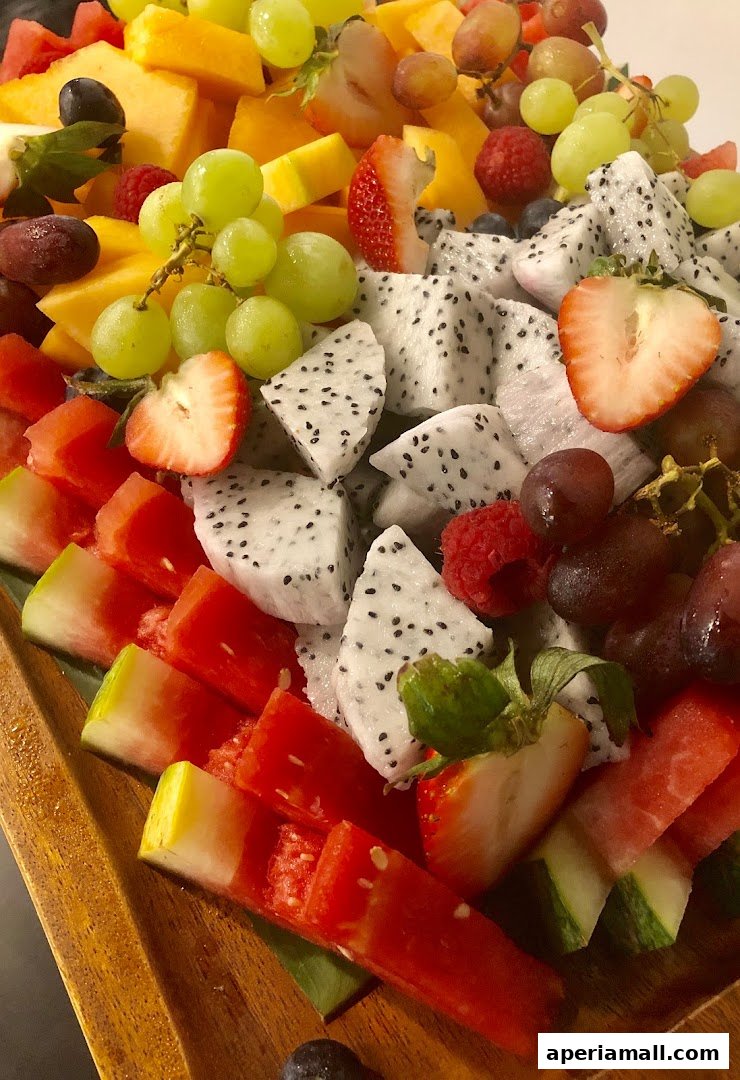 A vibrant platter overflowing with fresh, colorful fruits like strawberries, grapes, dragon fruit, and watermelon.