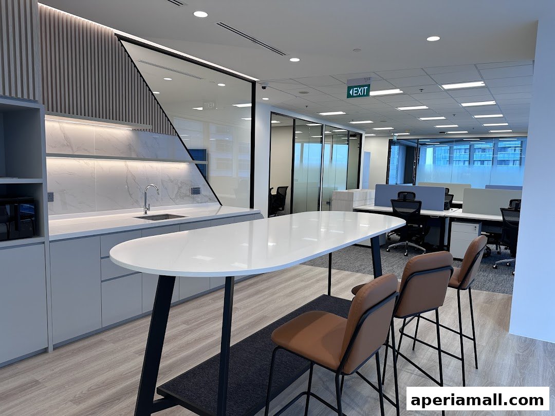Modern office interior with a sleek kitchen area and workstations.