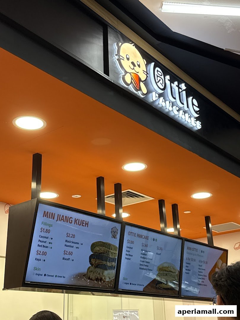 Digital menu boards displaying various pancake fillings, prices, and skin options at Ottie Pancakes.