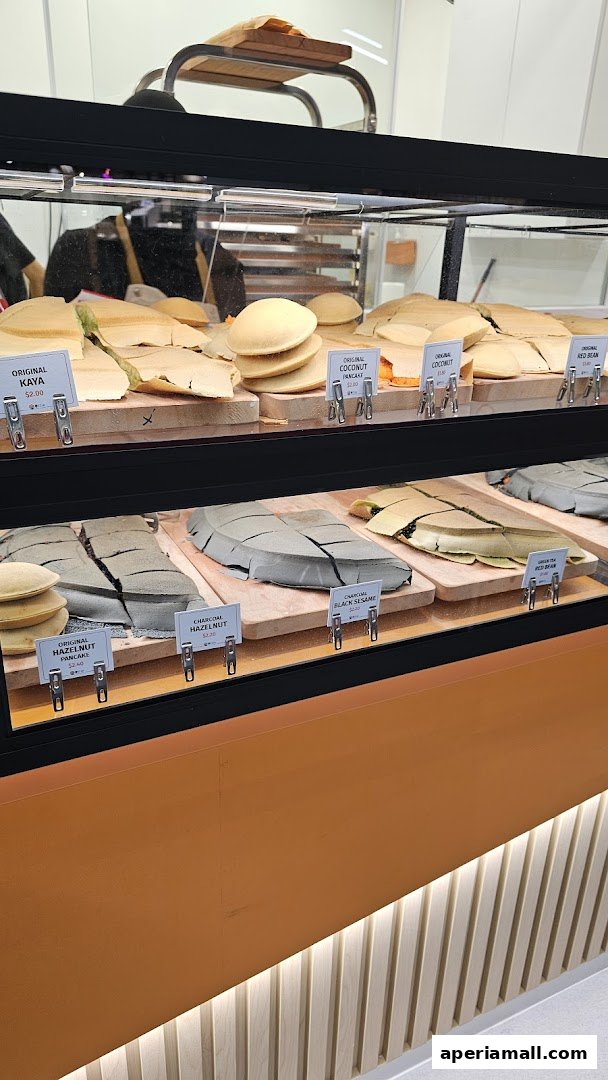 A display case filled with various flavors of pancakes, neatly arranged and labeled.
