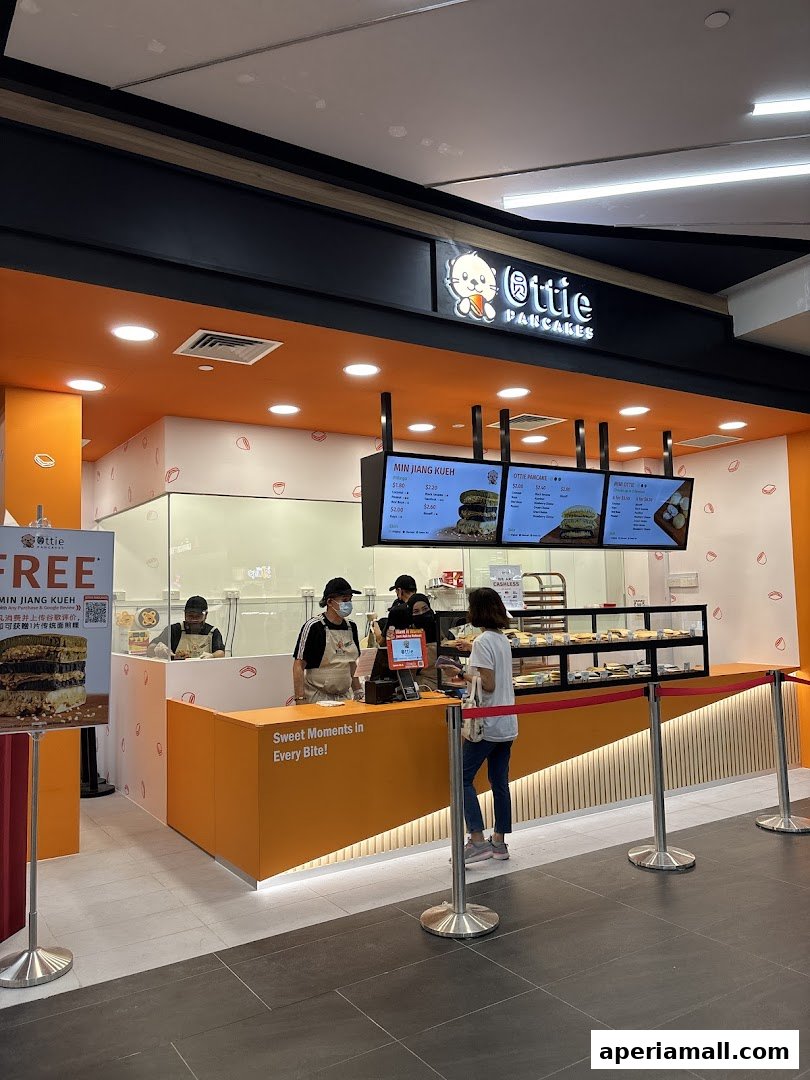 A bright and inviting Ottie Pancakes shop with staff serving customers at the counter.