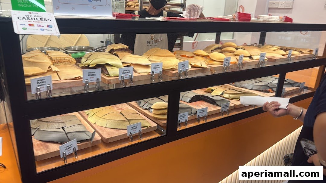 A display case filled with various flavors of Ottie Pancakes, a popular street food.