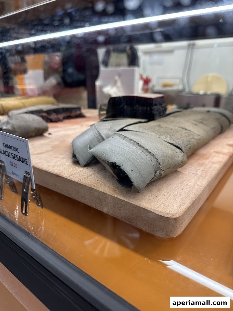 Close-up of charcoal black sesame pastries displayed in a refrigerated case.