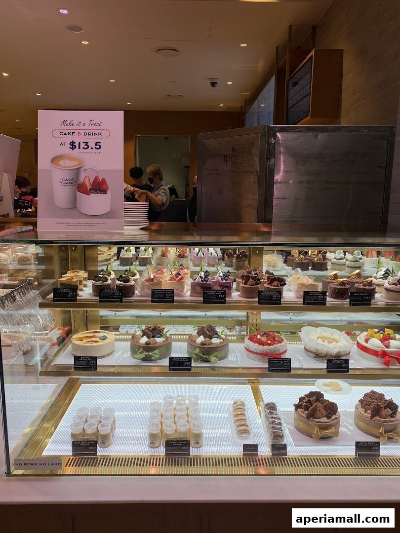 A display case filled with various cakes, pastries, and desserts at Paris Baguette.