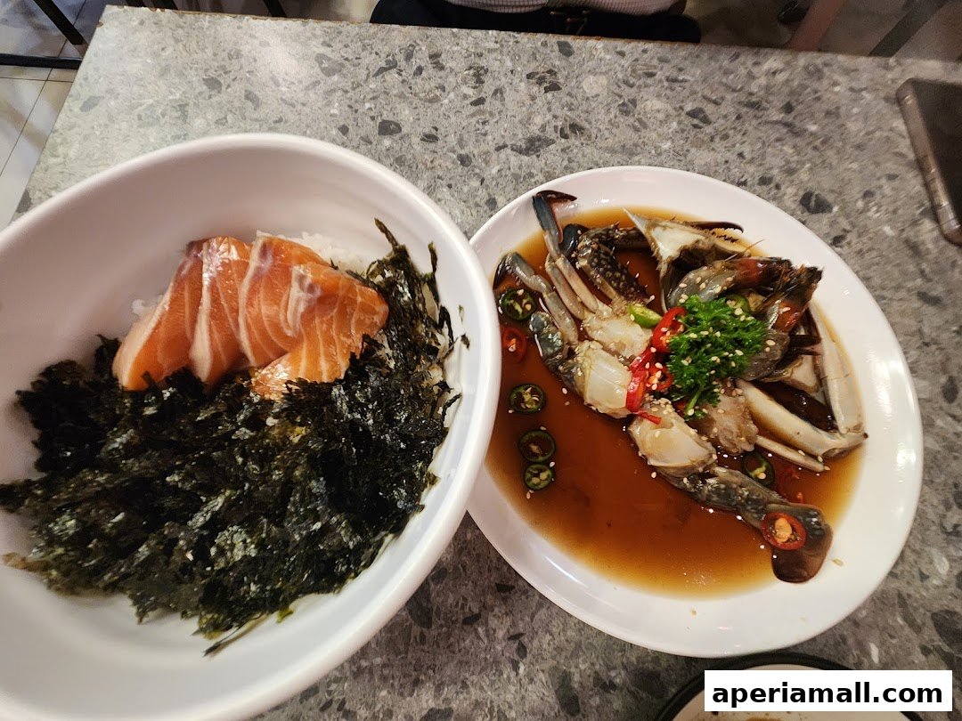 A bowl of salmon and seaweed next to a plate of marinated crab.
