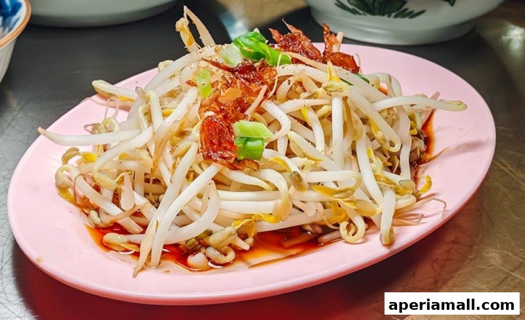 A plate of fresh bean sprouts with chili oil, fried shallots, and green onions.