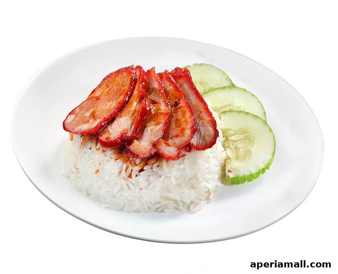 A plate of delicious char siu (barbecued pork) with rice and cucumber slices.