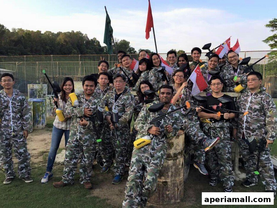 A group of people in camouflage outfits holding paintball guns and flags.