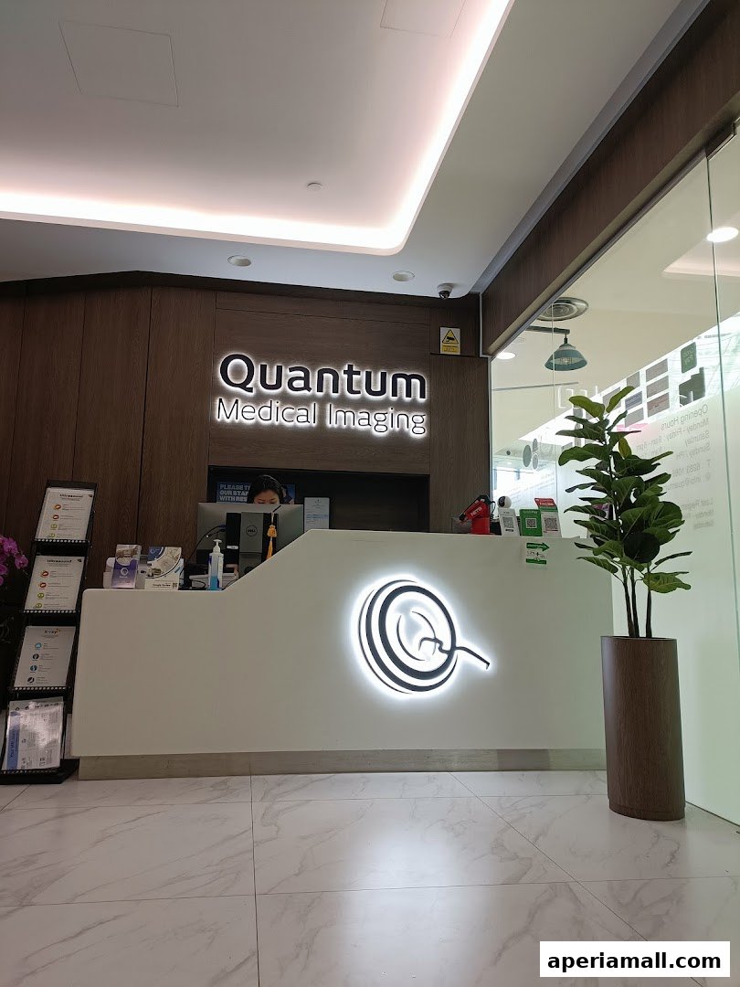 The reception area of Quantum Medical Imaging with a desk, staff, and branding.