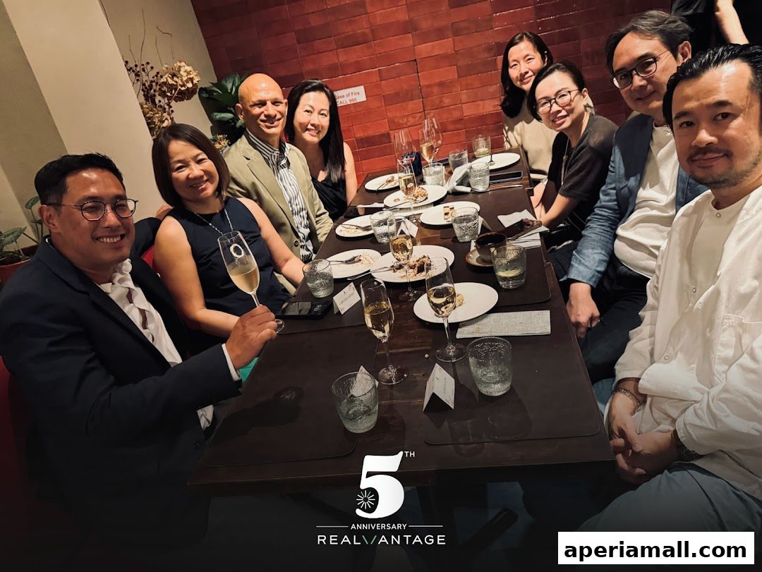 A group of people celebrating an anniversary at a restaurant with drinks and desserts.