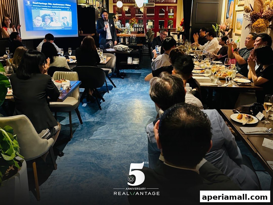 A group of people are seated at tables in a restaurant, watching a presentation.