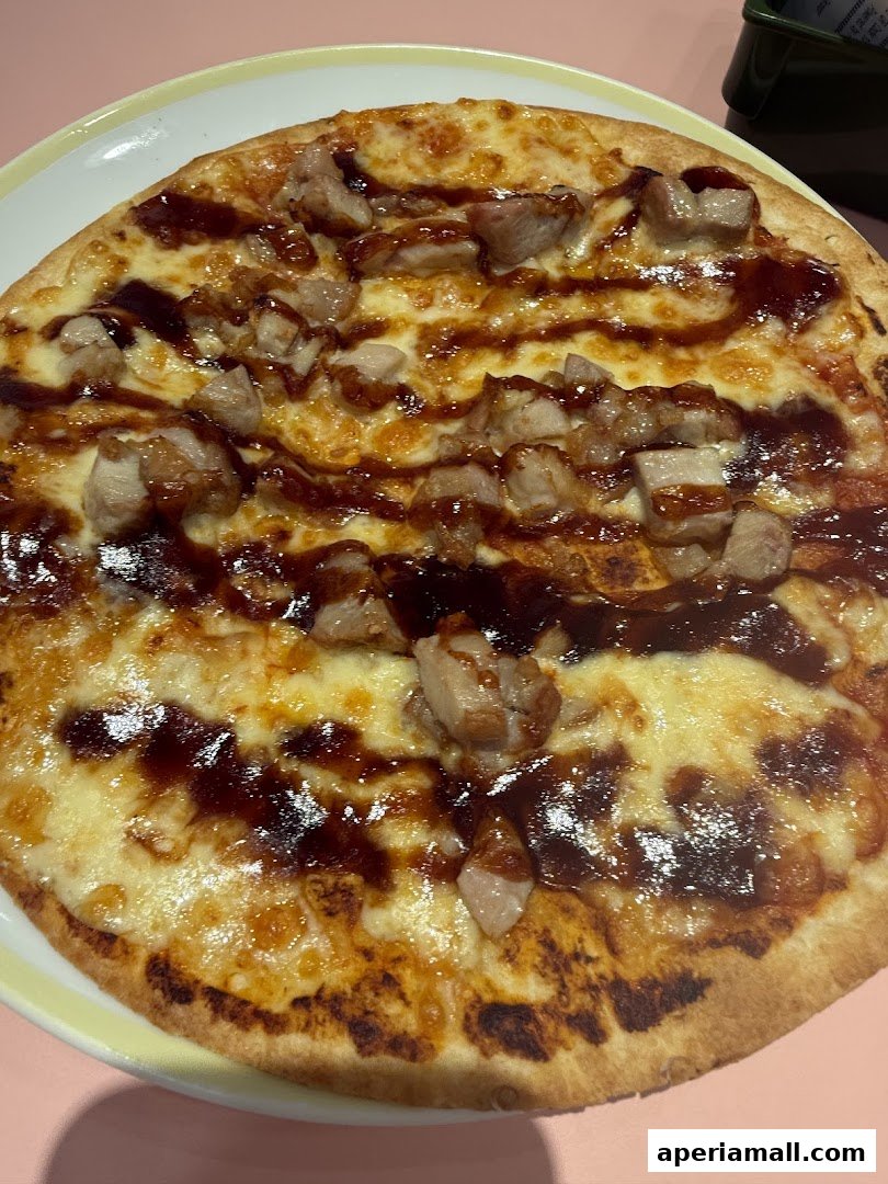 A close-up shot of a delicious pizza topped with chicken and barbecue sauce.