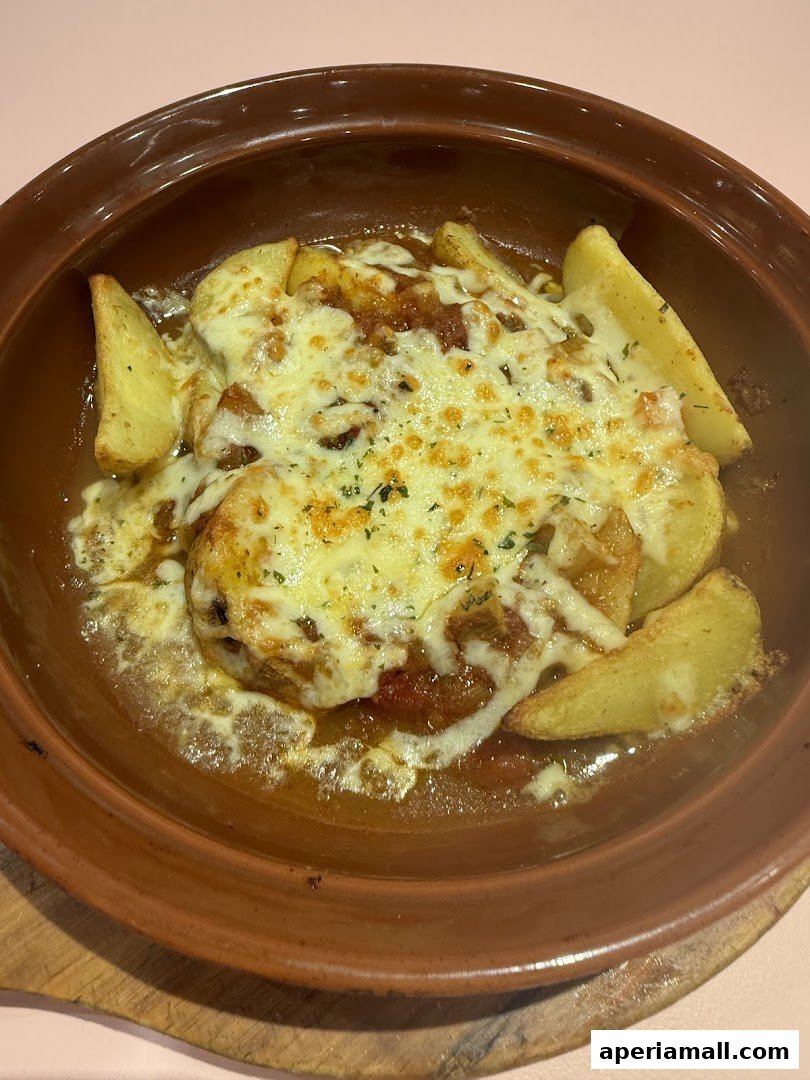 A close-up shot of a baked dish with potatoes and melted cheese.