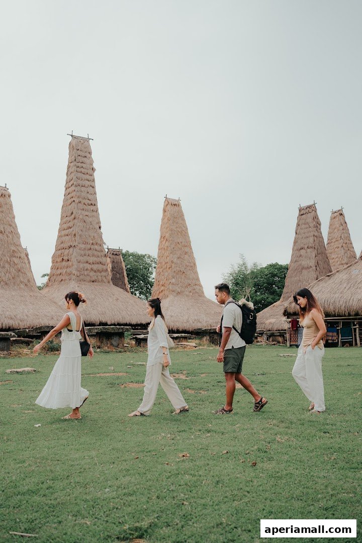 Four people walk past traditional thatched-roof houses with conical towers.