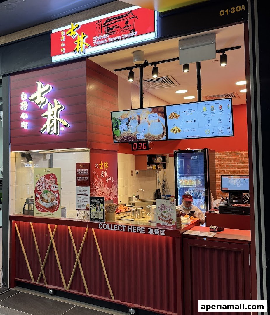A Shihlin Taiwan Street Snacks stall with a red facade and illuminated signage.