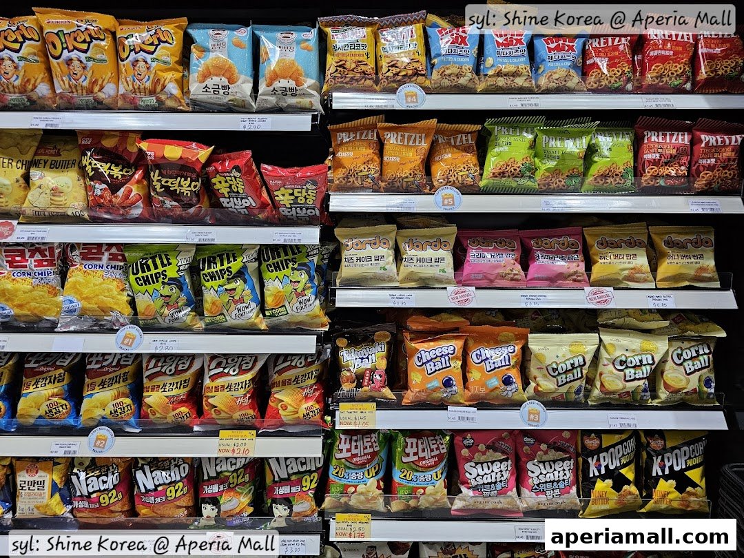 Shelves stocked with a variety of Korean snacks and chips, including pretzels and corn chips.