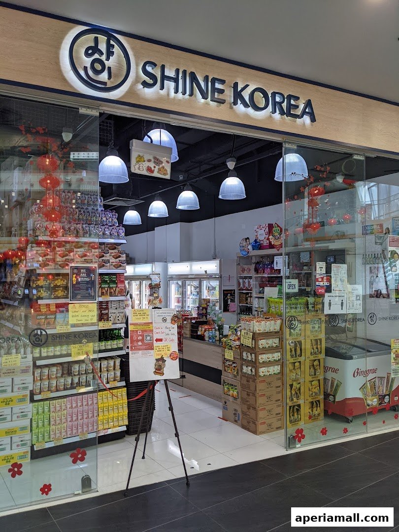 The entrance of Shine Korea, a Korean convenience store, filled with various products and promotional displays.