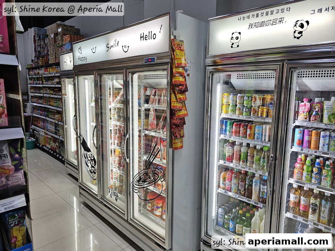 Refrigerated display cases filled with Korean snacks, drinks, and food items.