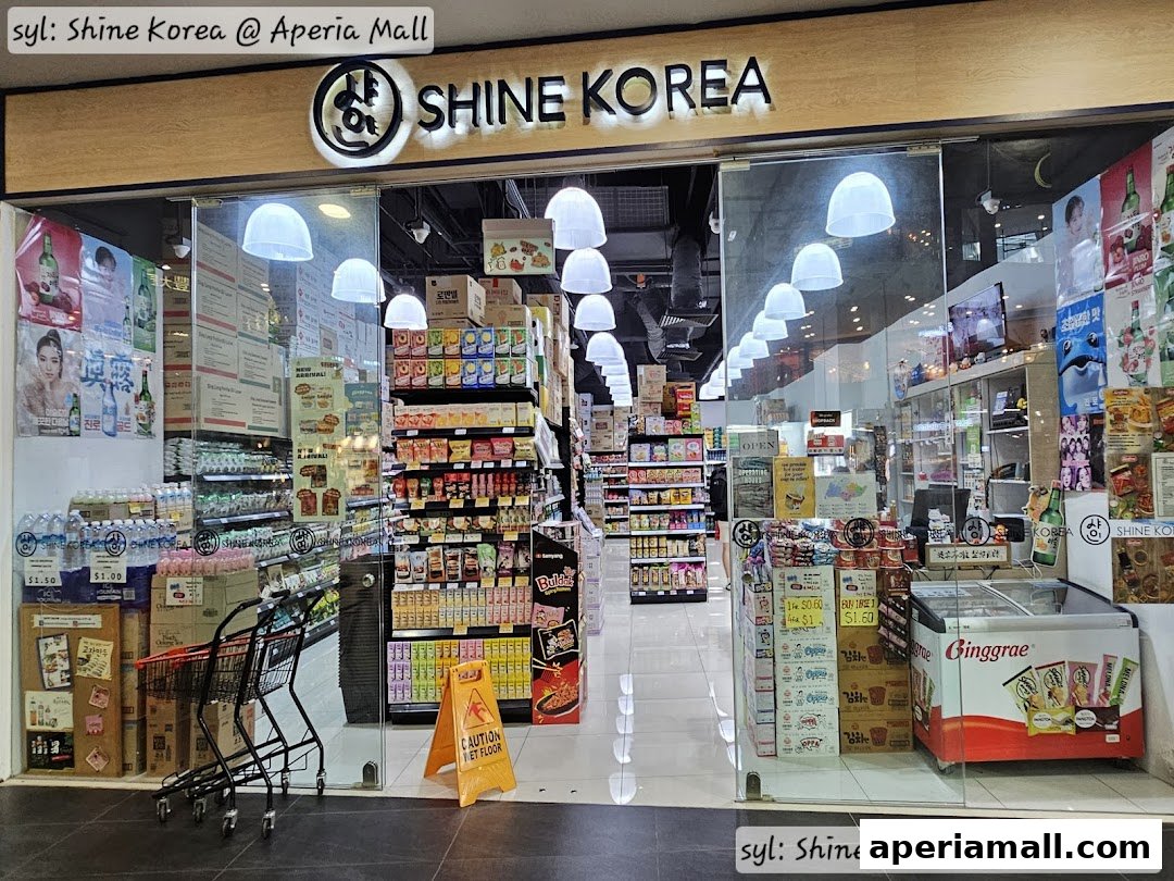 The entrance of Shine Korea, a Korean convenience store, filled with various products and promotional displays.