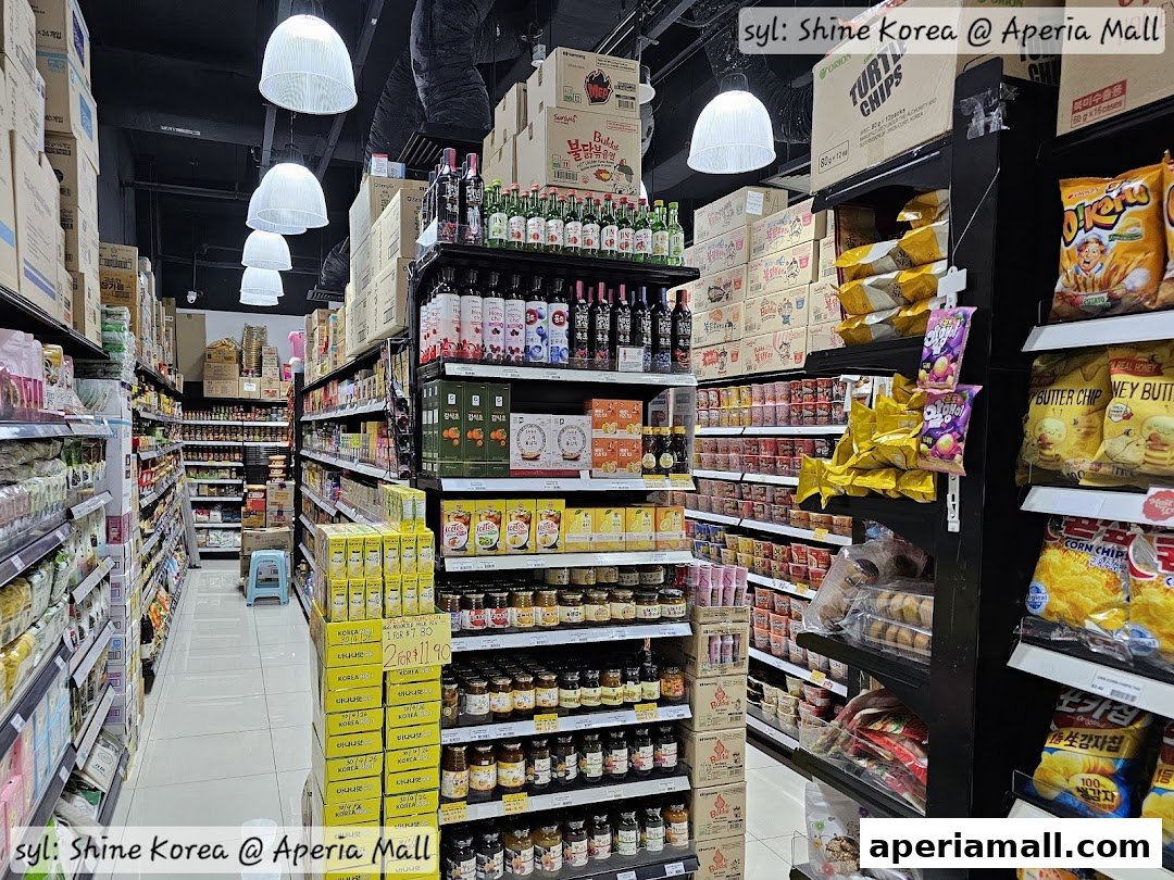 Aisle view of a Korean grocery store stocked with various snacks, drinks, and food items.
