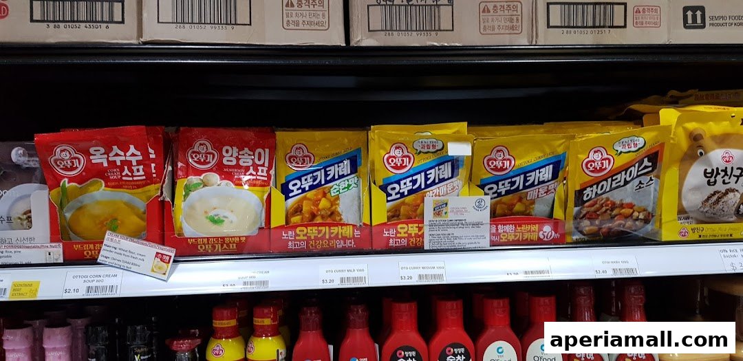 A shelf stocked with various Korean food products, including soups, curries, and sauces.