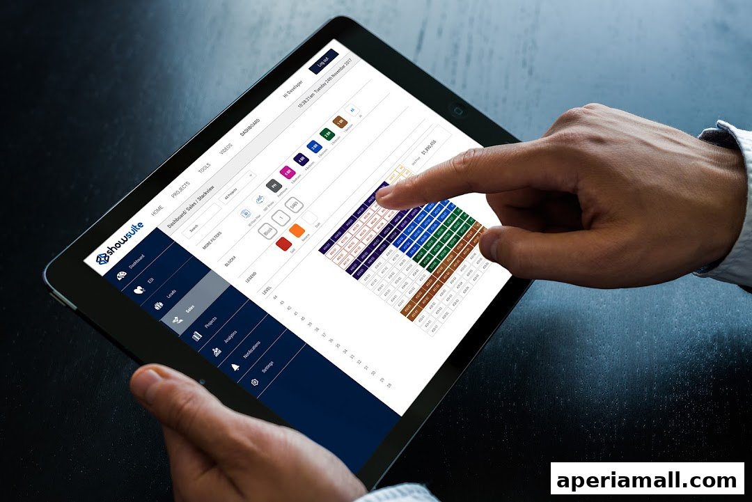 A person uses a tablet displaying a sales dashboard with a color-coded floor plan.