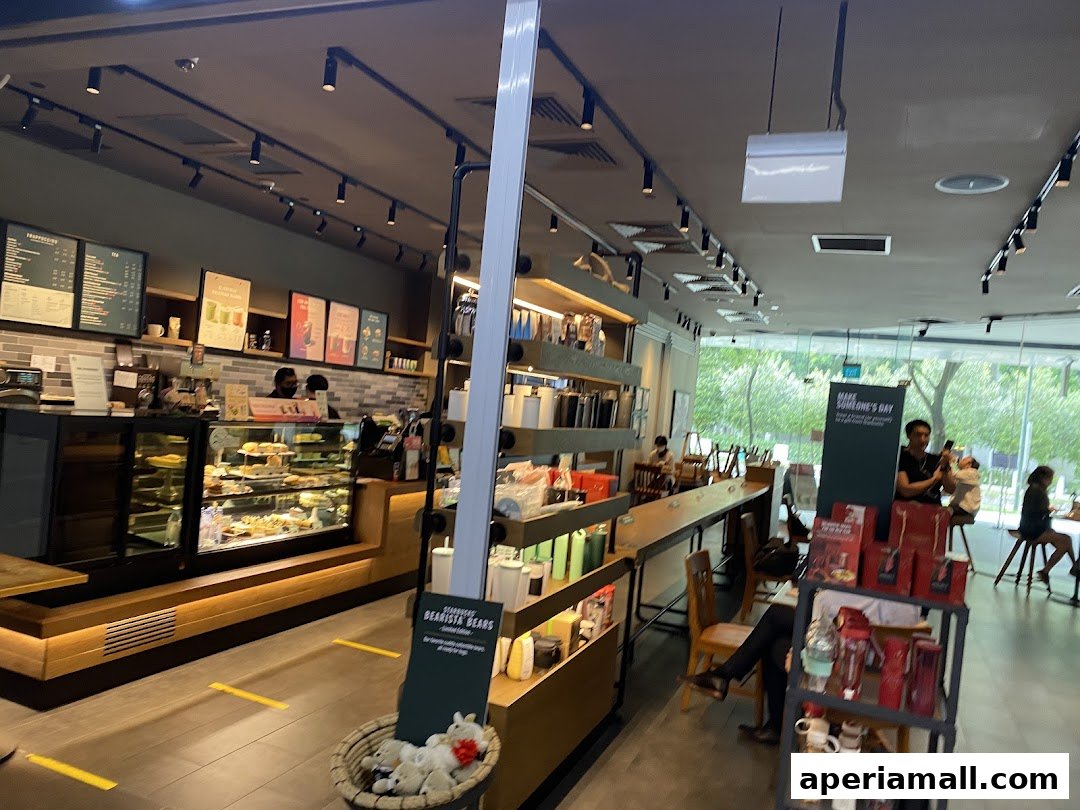 Interior view of a Starbucks coffee shop with a counter, display cases, and seating areas.