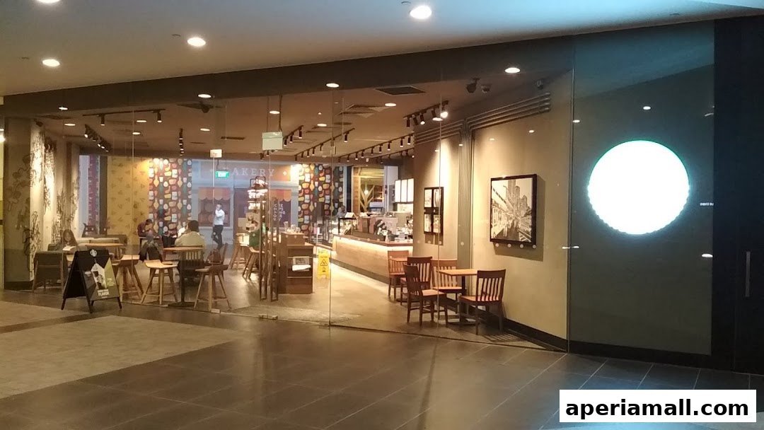 The exterior of a Starbucks coffee shop with seating inside and a large illuminated logo.