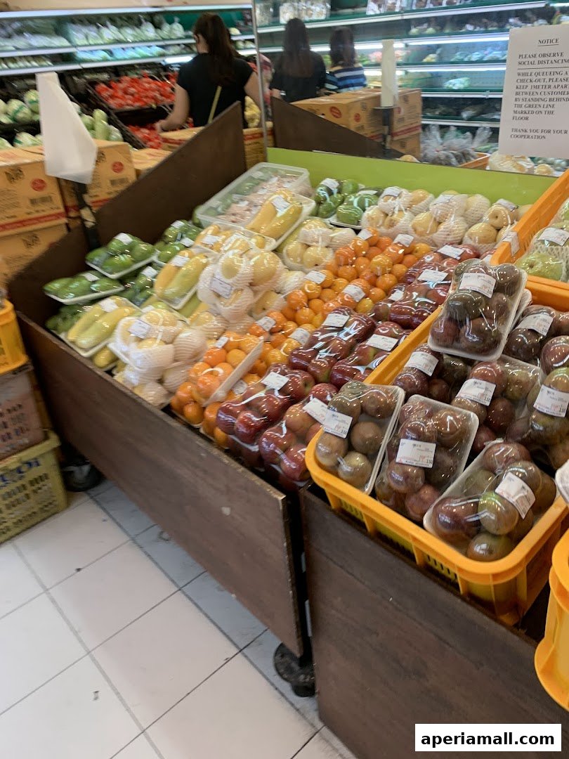 A display of fresh fruits and vegetables in plastic packaging at a supermarket.