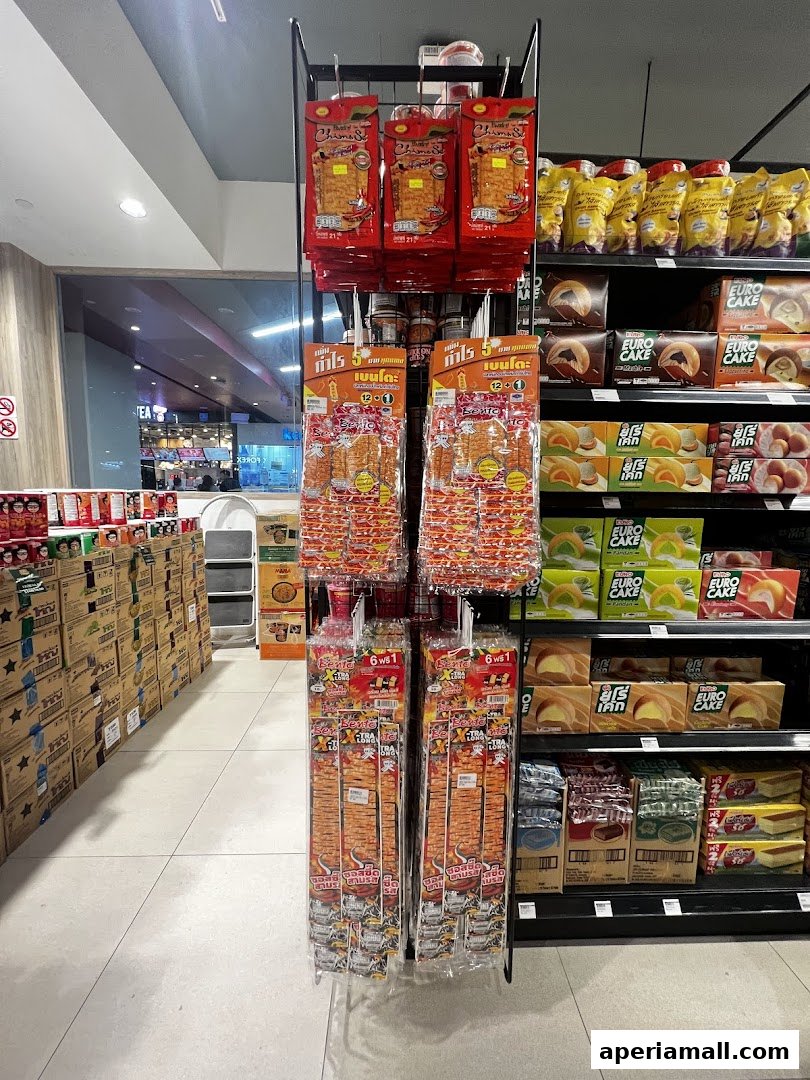 A display of various snacks and packaged food items in a supermarket aisle.
