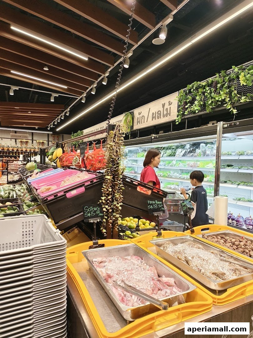A mother and son shop for fresh produce and seafood in a well-lit supermarket.