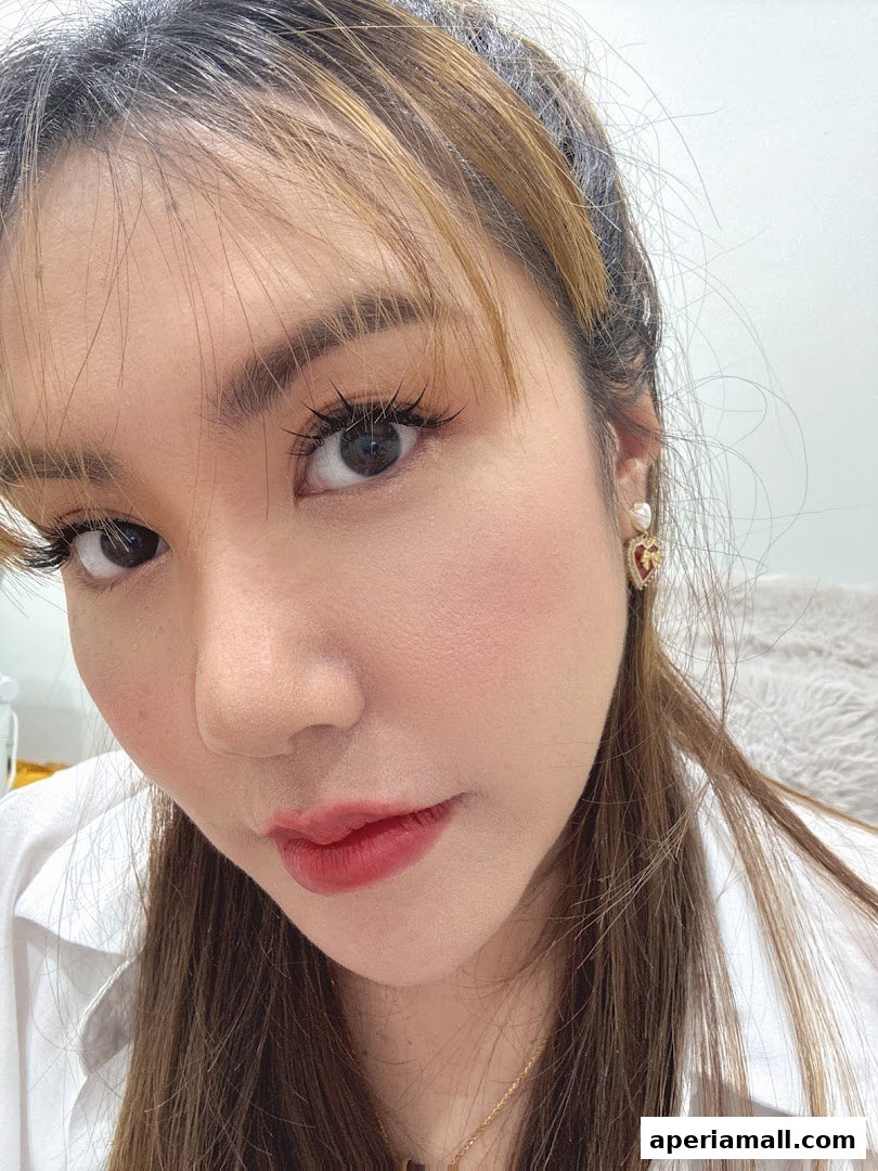 A close-up of a woman's face, showcasing makeup and earrings.