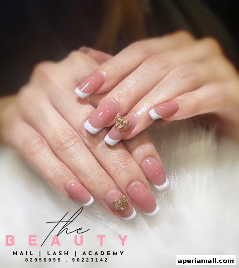 Close-up of hands with elegant French manicured nails adorned with gold butterfly charms.