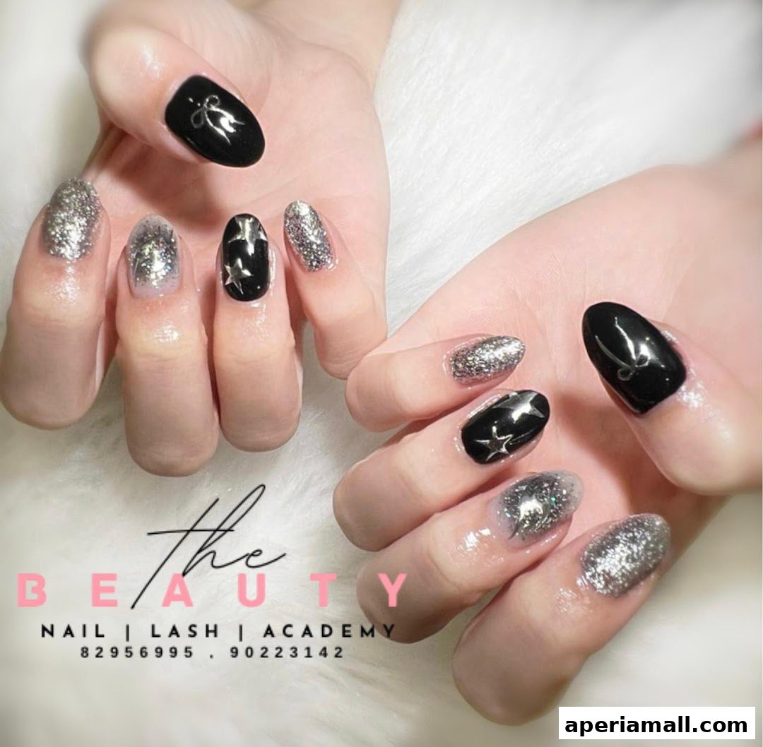 Close-up of hands with stylish black and silver glitter nail art.
