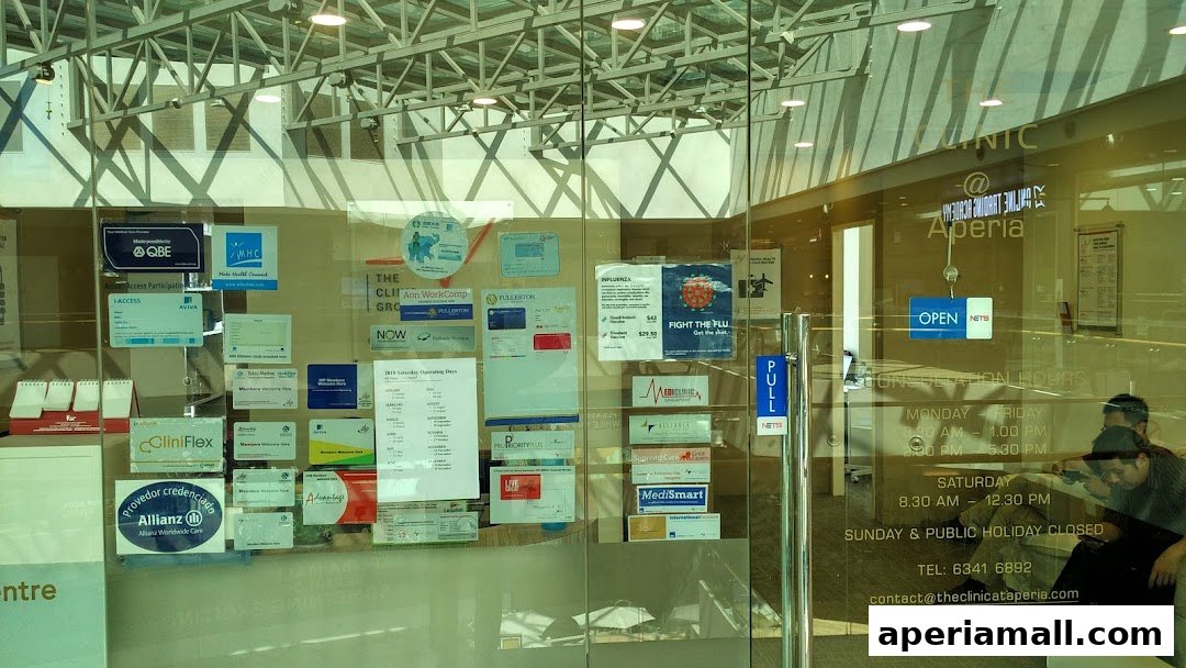 The entrance of The Clinic Group at Aperia, displaying various certifications and operating hours.
