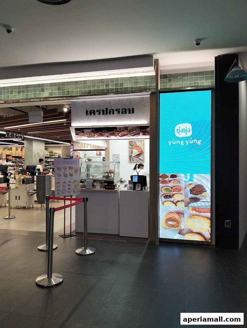 The Crispy Crepes shop front with a digital display showcasing various crepes and pastries.