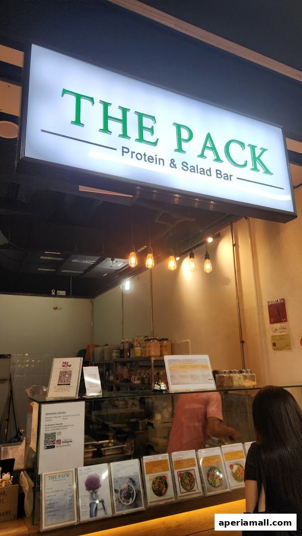 The Pack Protein & Salad Bar storefront with a menu display and staff behind the counter.