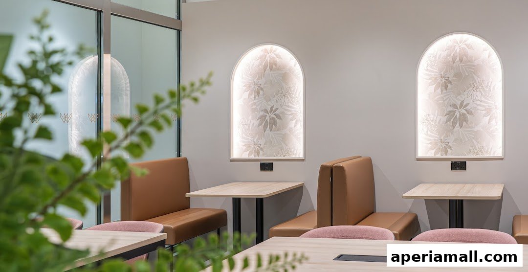 Interior shot of a modern cafe with comfortable seating and botanical-themed wall art.