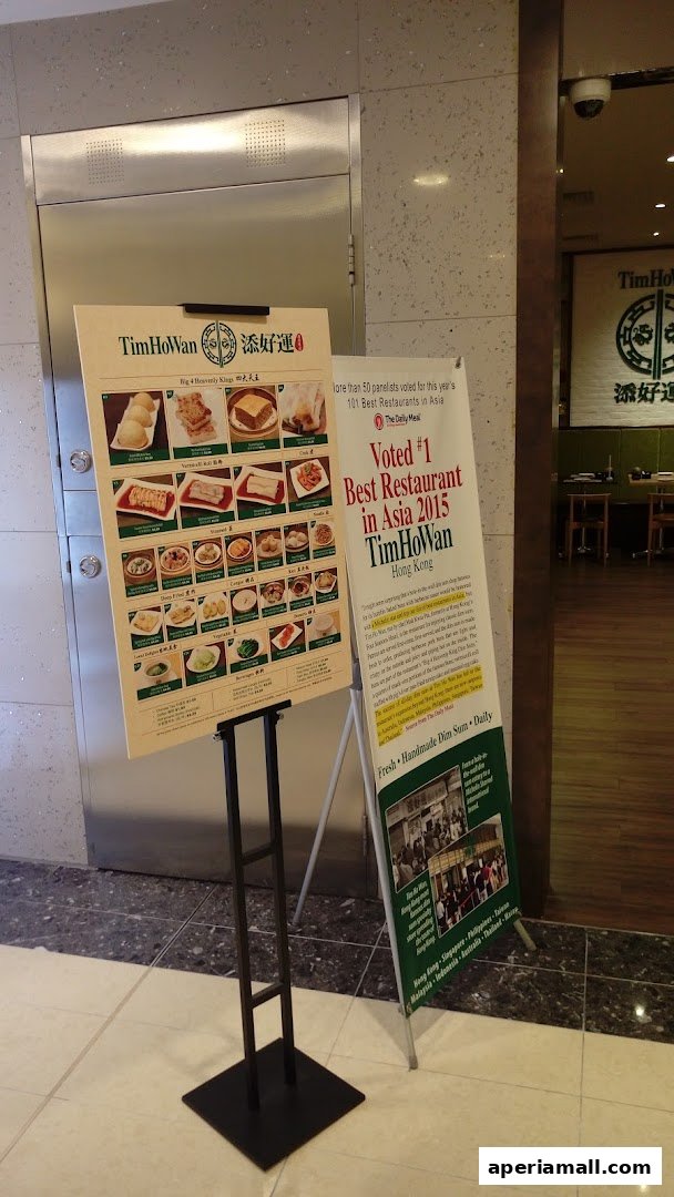 A menu board and promotional banner for Tim Ho Wan, a Hong Kong dim sum restaurant.