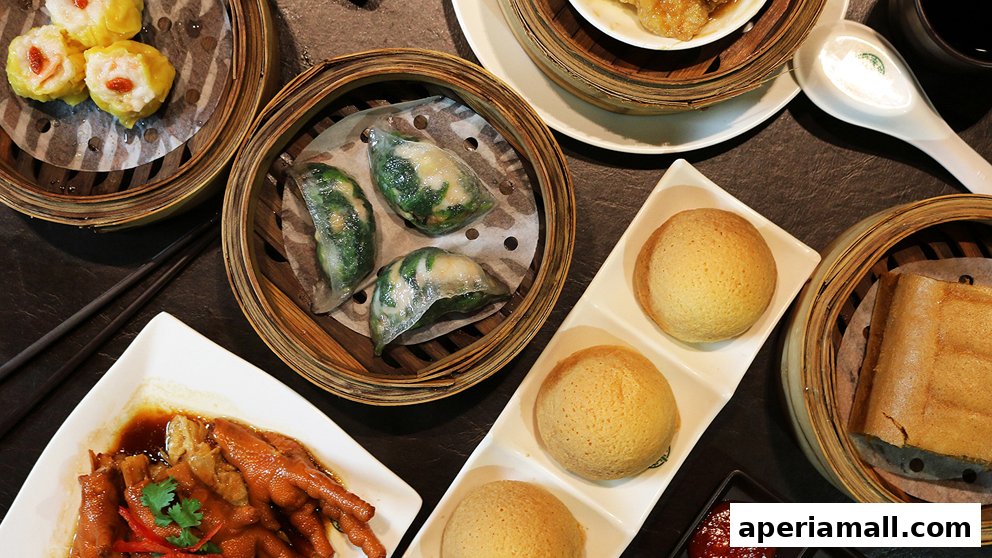 A spread of delicious dim sum dishes, including siu mai, har gow, chicken feet, and baked buns.