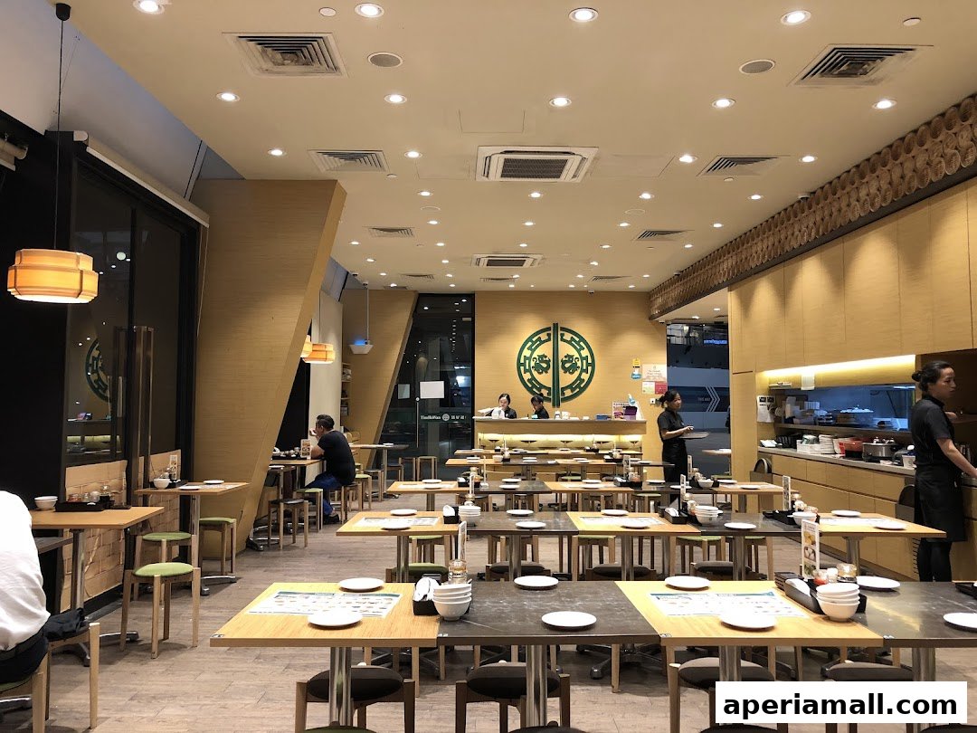 Interior view of a modern restaurant with many tables and chairs, and staff working.