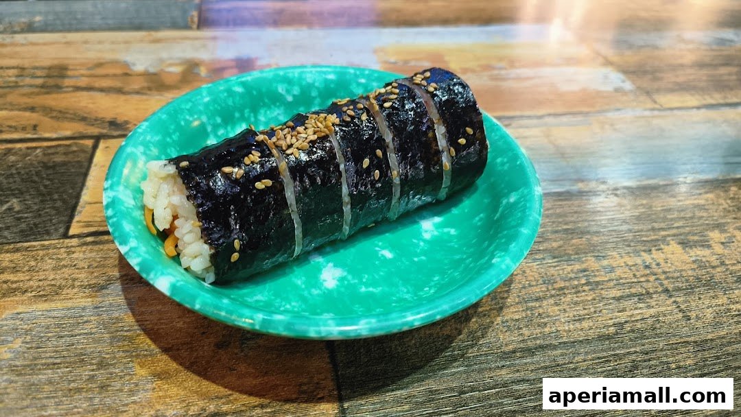 A close-up shot of a delicious kimbap roll on a green plate.