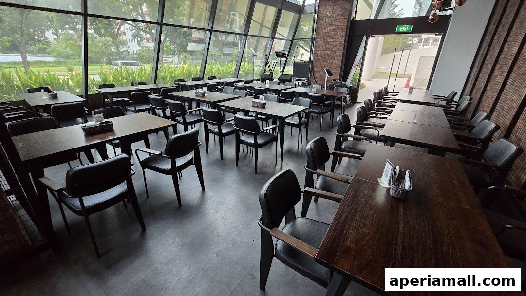 Interior of a restaurant with many tables and chairs, large windows, and an exit sign.