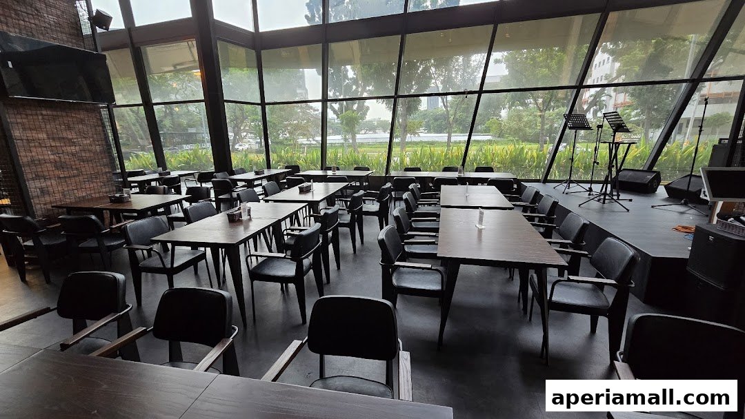 Interior of a restaurant with tables, chairs, and a stage with musical equipment.