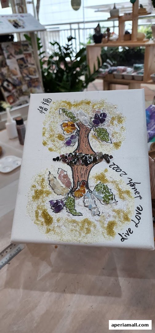 A canvas artwork featuring a tree of life made with colorful gemstones and glitter.