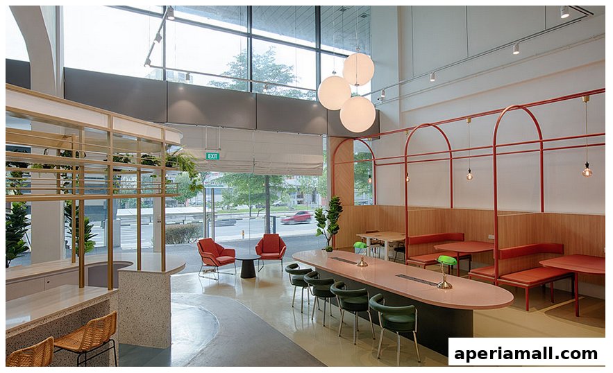 Interior of a modern cafe with booth seating, a long communal table, and plants.