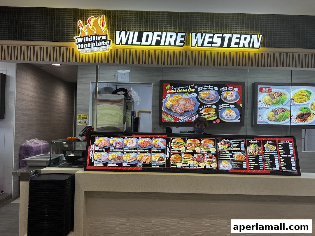 A food stall with a bright sign and a digital menu displaying various Western dishes.