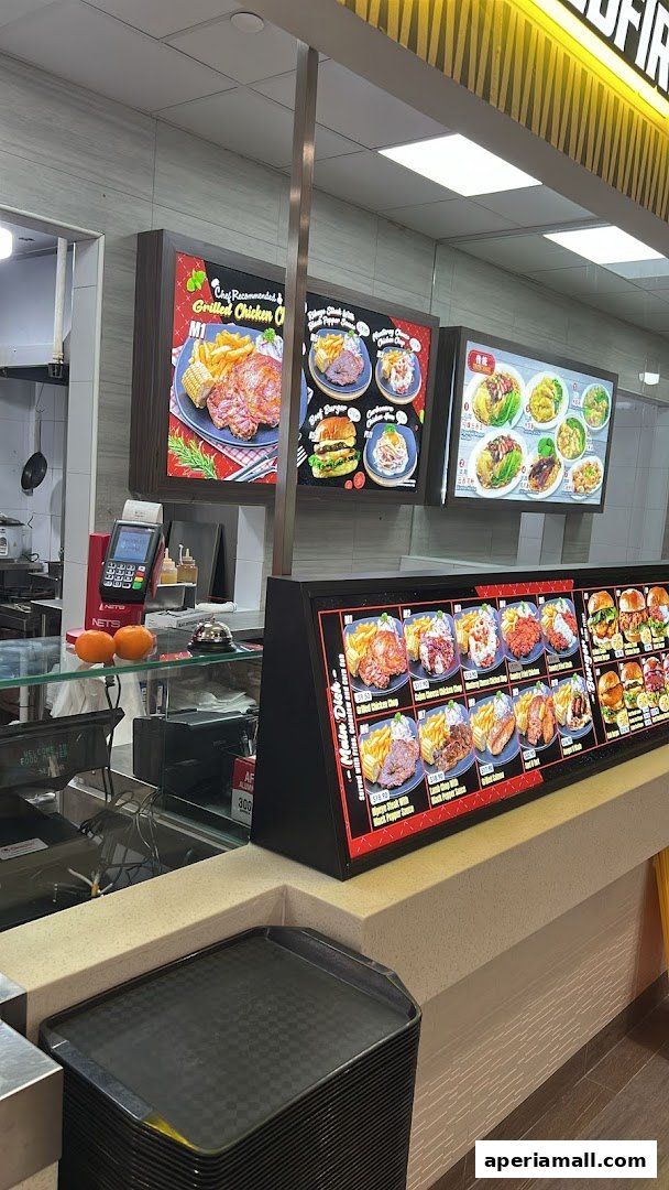 A food stall counter displaying various dishes and a payment terminal.