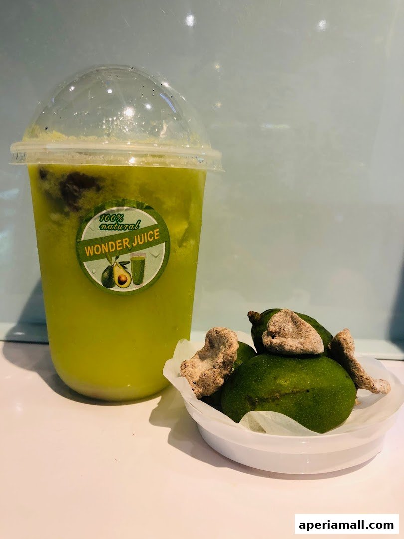 A refreshing green juice with a side of fresh limes and dried fruit.