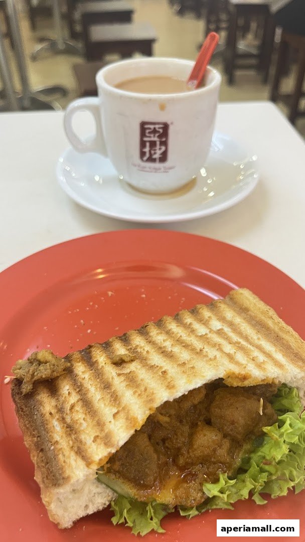 A close-up of a sandwich and a cup of coffee with the Ya Kun Kaya Toast logo.